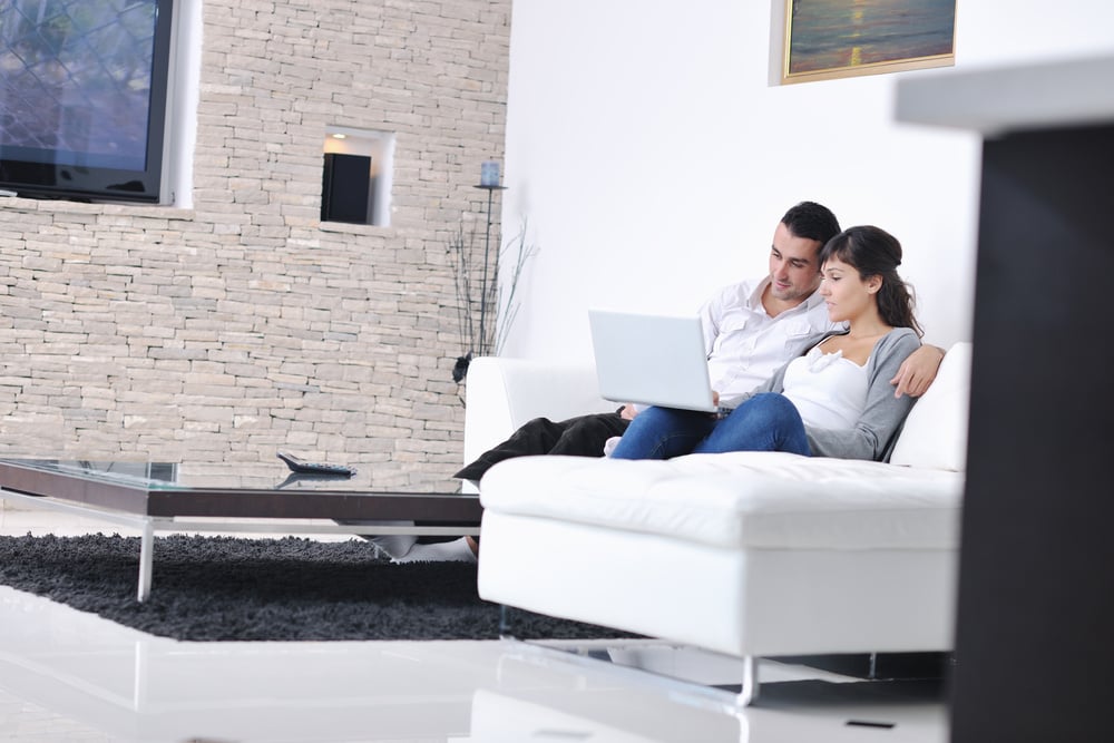 joyful couple relax and work on laptop computer at modern living room indoor home